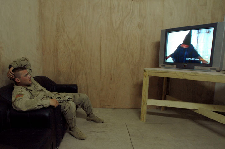 An American soldier watches President Bush's televised apology for Abu Ghraib. Iraq 2004.