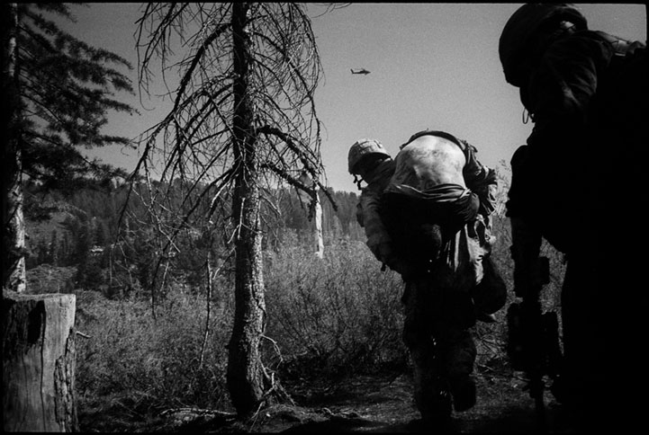 American soldiers carry away a comrade, after their position is overrun. Kunar, Afghanistan 2007.