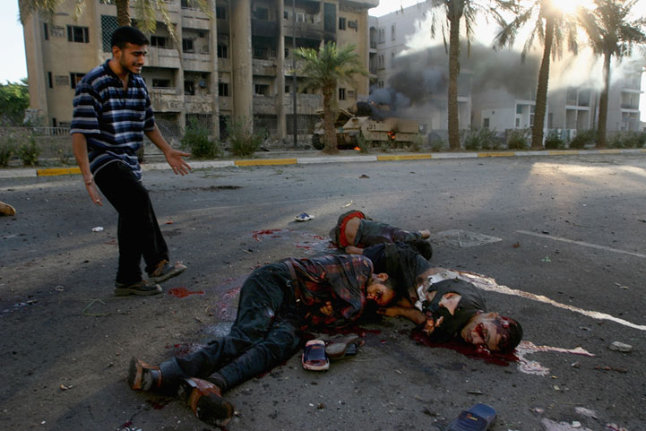 Iraqi civilians lie dying after US helicopters open fire on crowds celebrating around a burning US vehicle. Baghdad Iraq 2004.