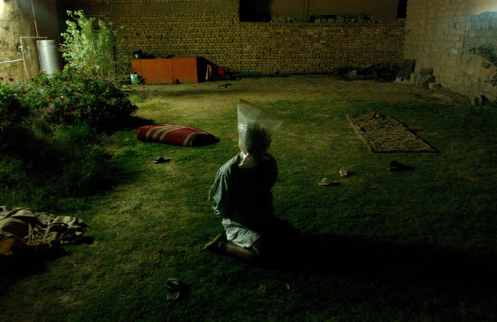 An Iraqi is detained in a midnight raid. 2004.